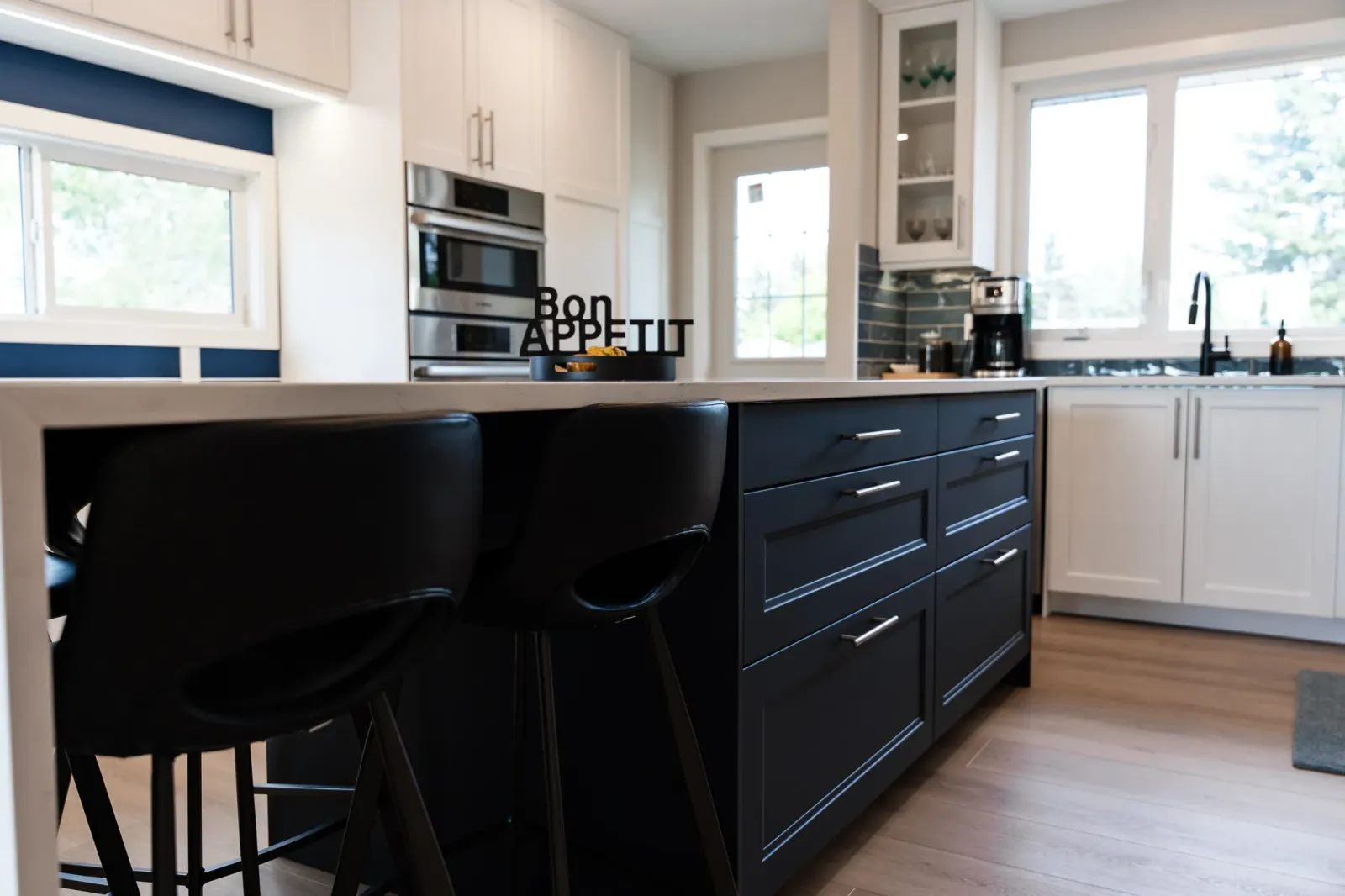 Modern flat-panel kitchen cabinetry with integrated appliances and matte dark hardware in Calgary