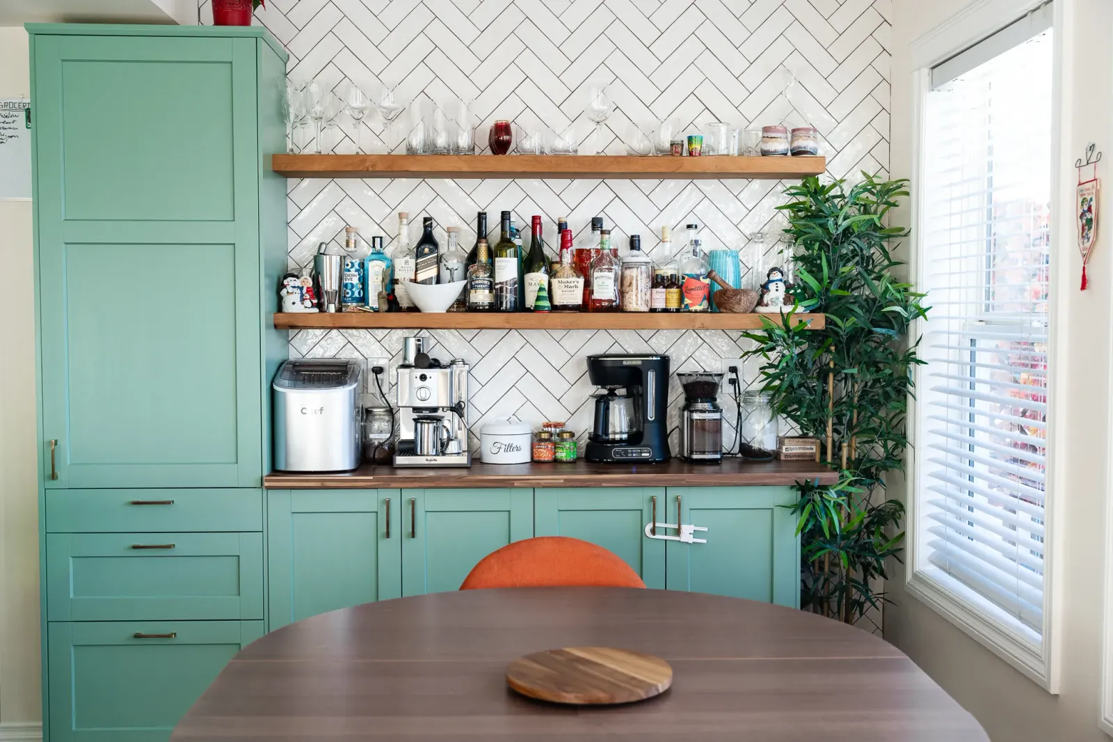 Custom floating shelves above a dining room coffee bar with herringbone tile in a Calgary home