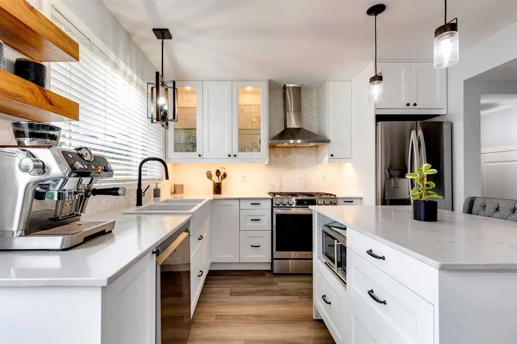 Polished stone countertops and white shaker cabinets in a complete Calgary kitchen makeover