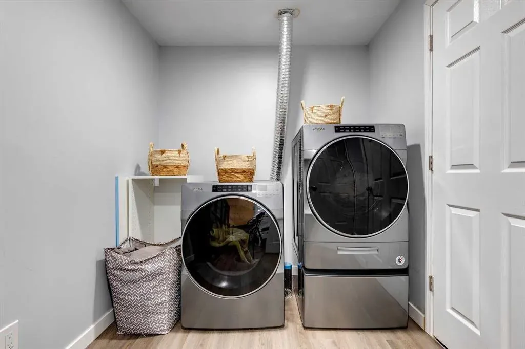 Sleek appliances and custom storage in a renovated basement laundry room in Calgary