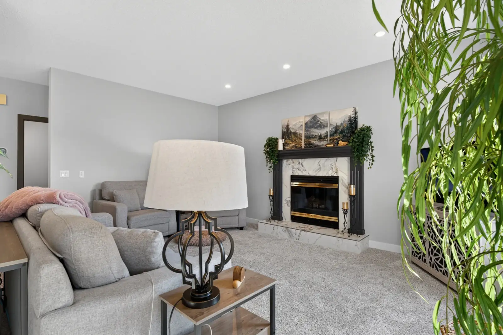 Renovated Valley Ridge Calgary living room with new carpet, grey walls and marble-look fireplace surround